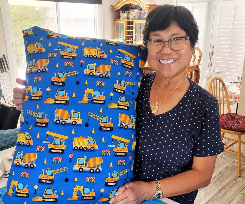 Family artisan showcasing custom embroidered pillow work